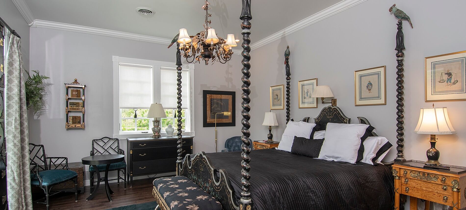 Striking bedroom with unique turned-posts on bed, black bedding and furniture.